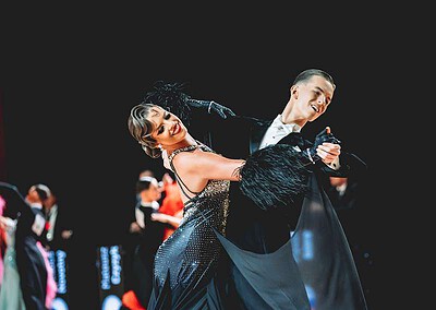 Duo tance v elegantních kostýmech na taneční soutěži Brno Open Mistro World Championship 2023, předvádějící techniku a eleganci na parketu.