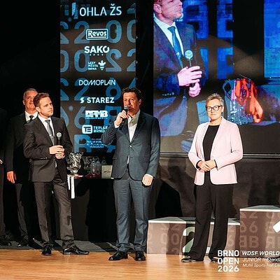 Skupina lidí na pódiu během BrnoOpen 2026, s velkým displejem v pozadí a řečníky v oblecích, prezentující událost a ocenění.