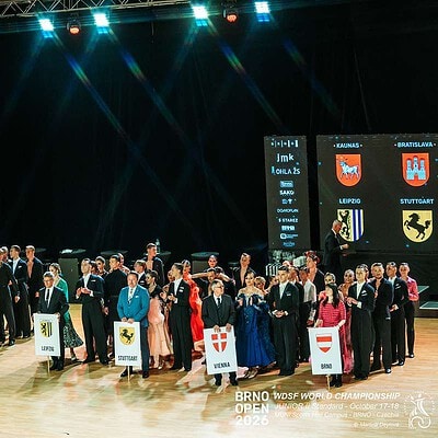 Skupina šachistů na ceremoniálu Brno Open 2026 s vlajkami různých zemí a velmistry v pozadí.