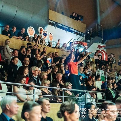 Fotografie z turnaje BrnoOpen 2023, zobrazuje diváky a účastníky v hale, s logy a dekoracemi soutěže.