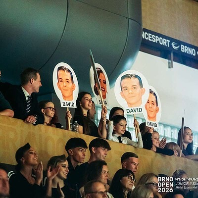 Mladí tanečníci a porota na soutěžním pódiu BrnoOpen 2026, s plakáty s jejich fotografiemi a názvem akce v pozadí.