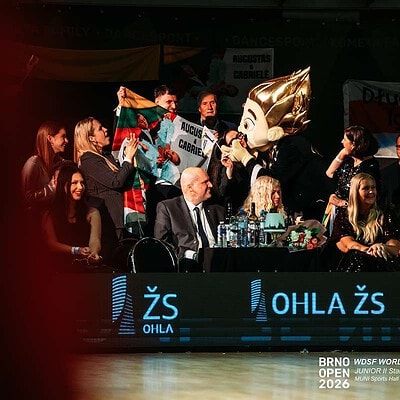 Taneční soutěž BrnoOpen 2026 s účastníky a maskotem na pódiu, diváci a porota v pozadí, sportovní akce v Brně, Česká republika.