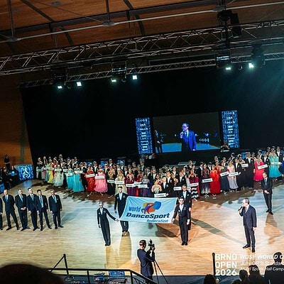 Skupina tanečníků a porota na taneční soutěži Brno Open 2024, velké taneční pódium s velkým LED displejem v pozadí.